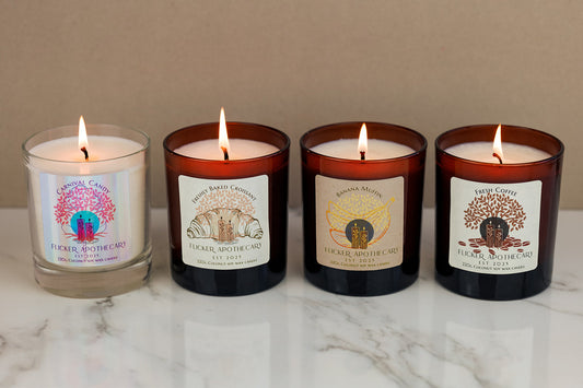 Bakery scented candles by Flicker Apothecary including banana muffin, croissant, hot cross bun and vanilla caramel candles in brown glass jars styled on a cosy kitchen surface.